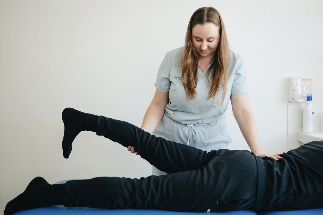 Physical therapist performing hands-on leg treatment